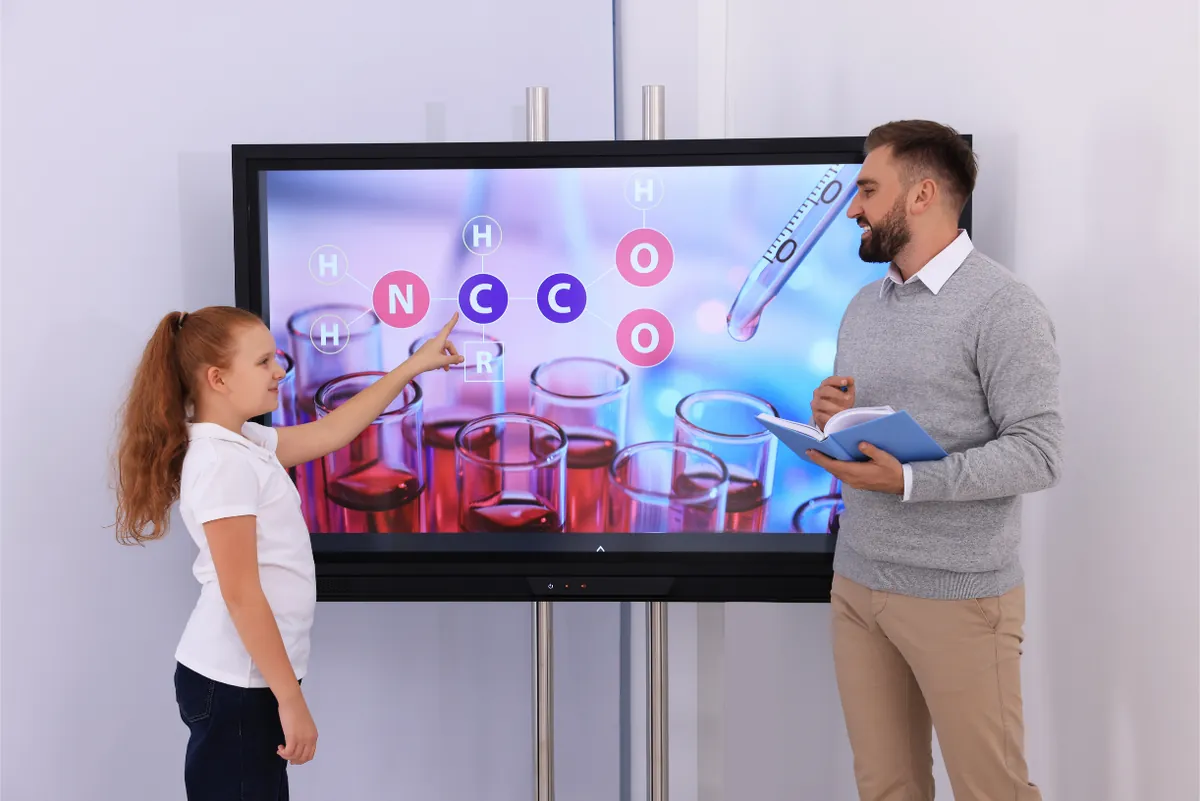 Teacher and student using an interactive display in a science lesson